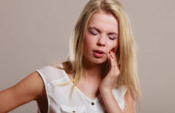 Closeup young woman face worried girl suffering from tooth pain