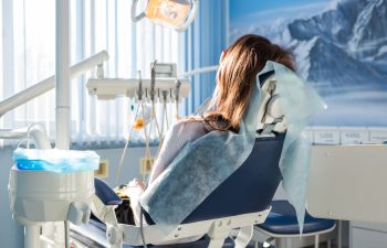 Patient sitting on dental chair, waiting for her dentist. Dental medicine, dental care, prevention, health concept.